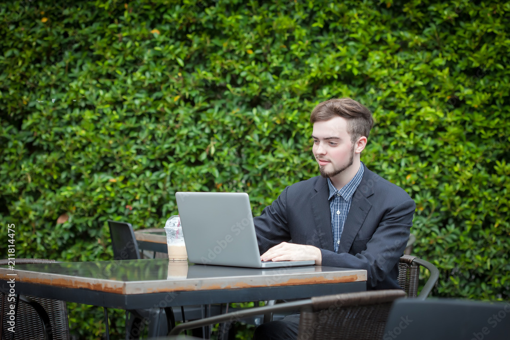 Portrait of young businessman using laptop in modern coffee shop outdoor Portrait of young businessman using laptop in modern coffee shop outdoor