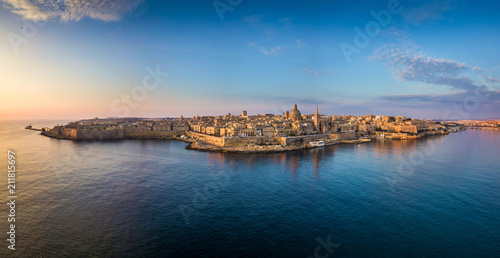 Fotografia Valletta, Malta - Aerial panoramic skyline of Valletta at sunrise with Our Lady of Mount Carmel church and St