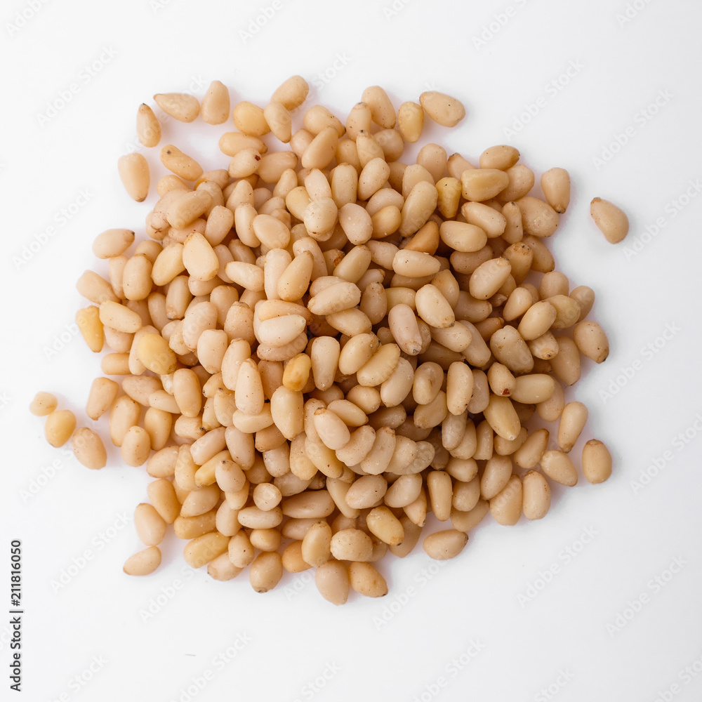 peeled pine nuts on a white acrylic background peeled pine nuts on a white acrylic background