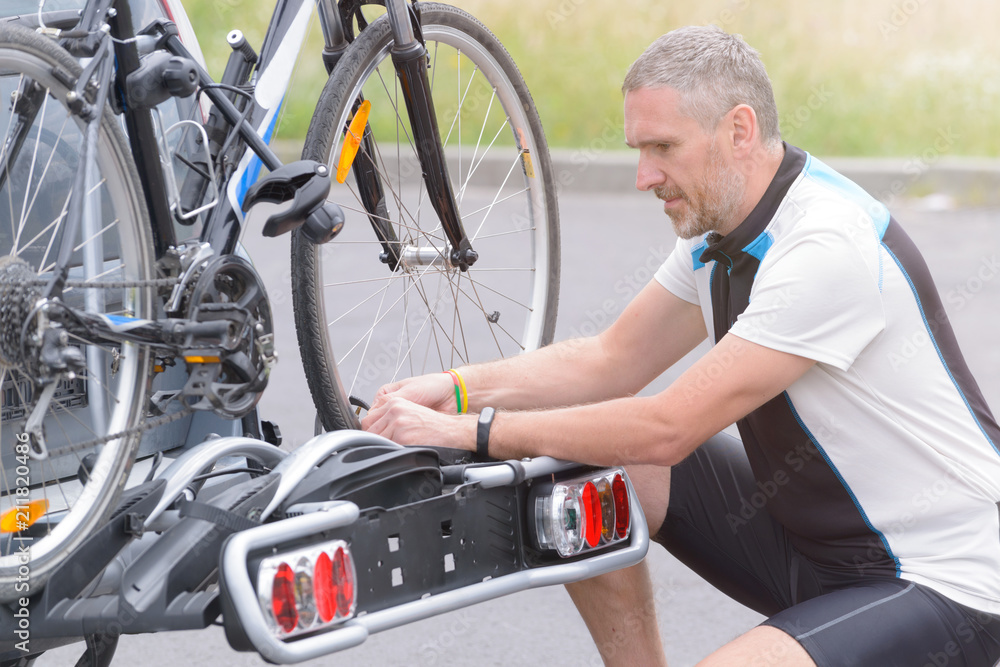 Fototapeta premium Man loading bicycles on the bike rack