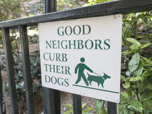 sidewalk urban street sign "good neighbors curb their dogs"