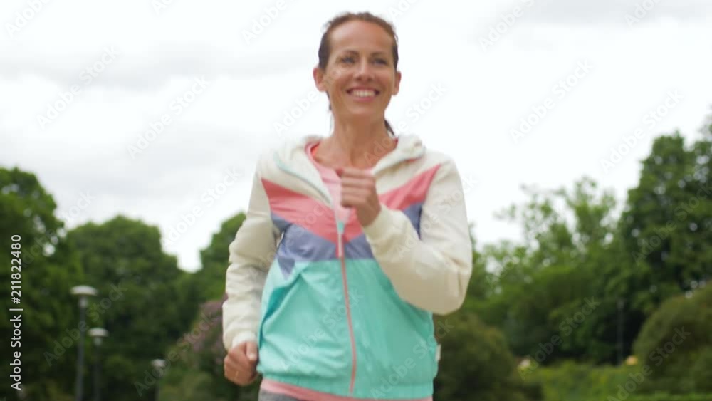 fitness, sport and healthy lifestyle concept - smiling woman running along park fitness, sport and healthy lifestyle concept - smiling woman running along park