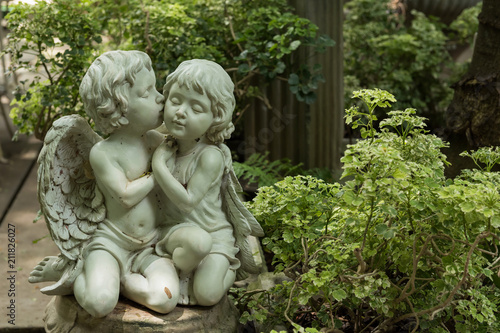 Cute kissed couple cupid in garden
