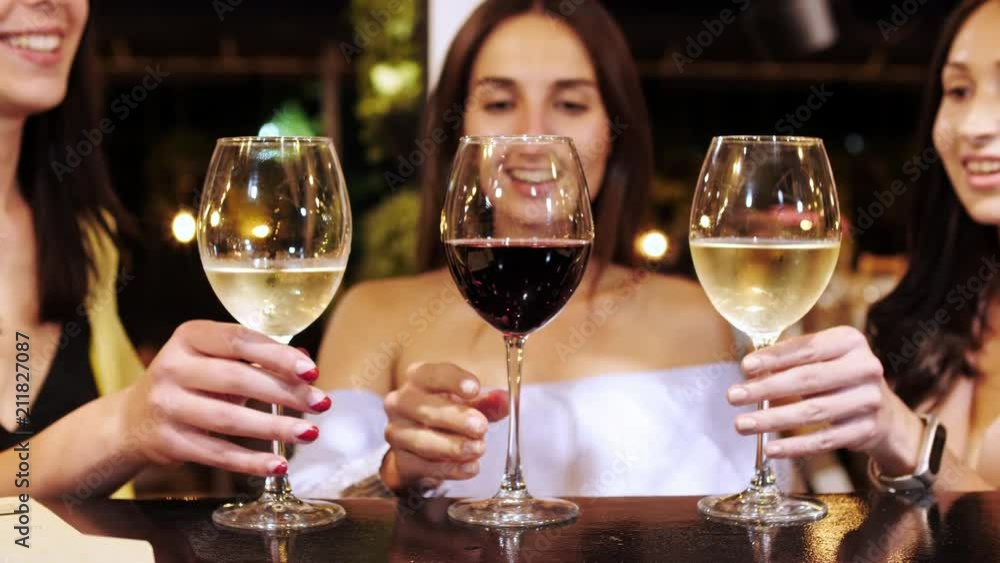 Three pretty girls are clink glasses with drinks at the bar. Three pretty girls are clink glasses with drinks at the bar.