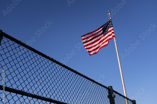 American Flog Red White And Blue Above A Fence