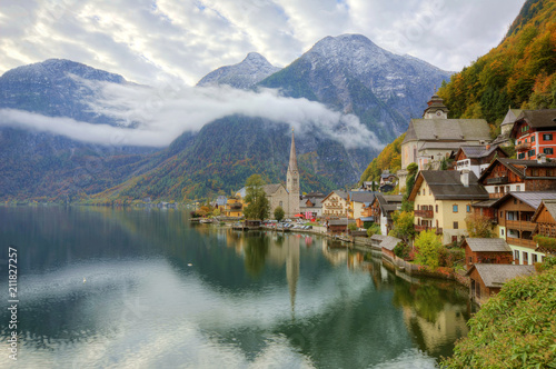 Morning view of Hallstatt, a peaceful lakeside village in Salzkammergut region of Austria, with majestic mountains reflected on lake water in colorful autumn season ~ A beautiful UNESCO heritage site © AaronPlayStation