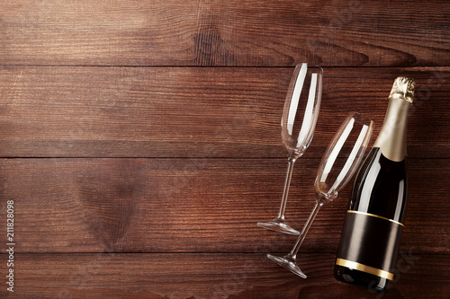 Champagne bottle with glasses on wooden table