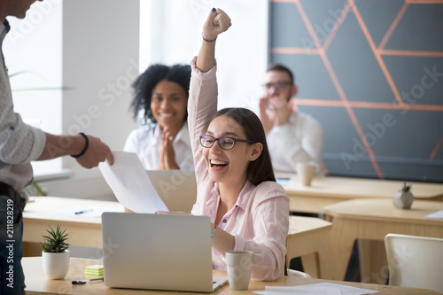 Excited female student screaming with happiness, getting high-evaluated exam sheet, satisfied female worker showing best work results, receiving new position promotion letter. Concept of reward © fizkes
