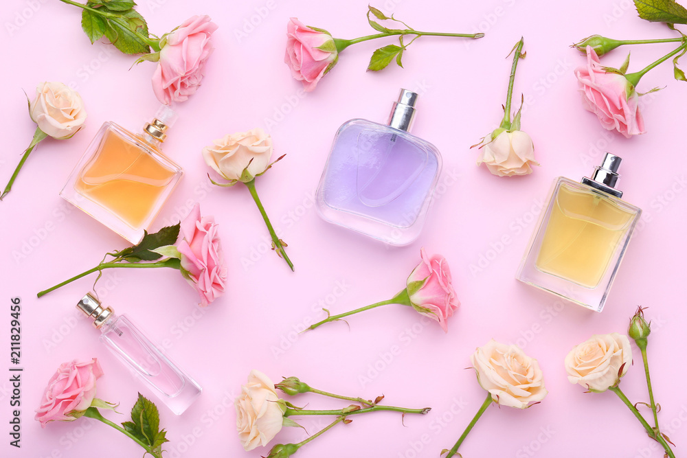 Perfume bottles with flowers on pink background - obrazy, fototapety, plakaty 
