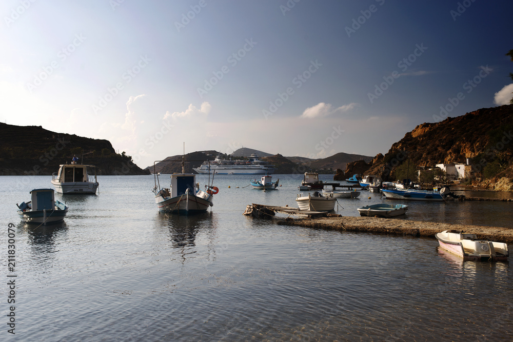 A view of fishing boats and a cruise ship in the beach in the island of Patmos in summer time