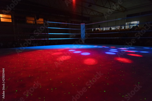 empty boxing ring in the beams of searchlights photo