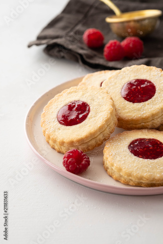 Traditional Christmas Linzer cookies with sweet jam on plate, closeup, copy space.