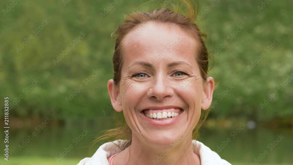 people concept - portrait of happy smiling middle-aged woman in park people concept - portrait of happy smiling middle-aged woman in park