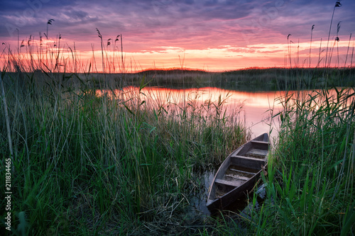Wooden boat on the lake at sunset