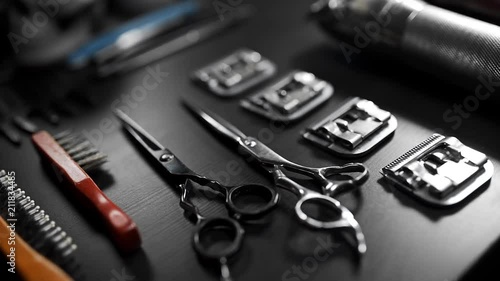 Table with scissors and trimmers at the barber shop, making of haircuts, straight razor on the table, shaving at barber shop