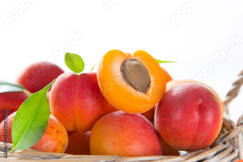 Fresh apricots on a white wooden background.