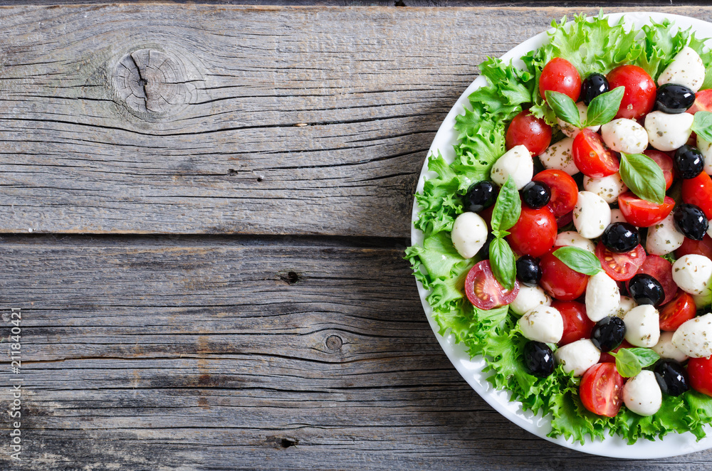 Salad with basil , tomatoes , olives and mozzarella Salad with basil , tomatoes , olives and mozzarella