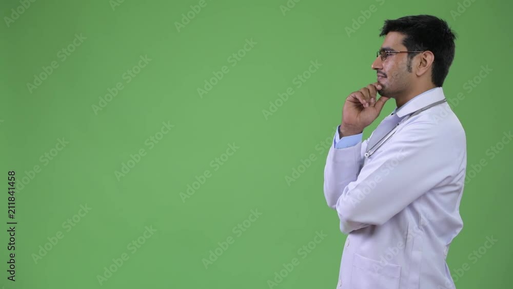 Profile view of young handsome Persian man doctor thinking Profile view of young handsome Persian man doctor thinking