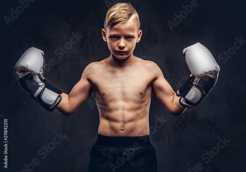 Принти на полотні Young shirtless boy boxer with boxing gloves posing in a studio