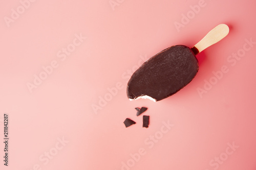 chocolate ice cream bite and crumbled on a pink background. summ