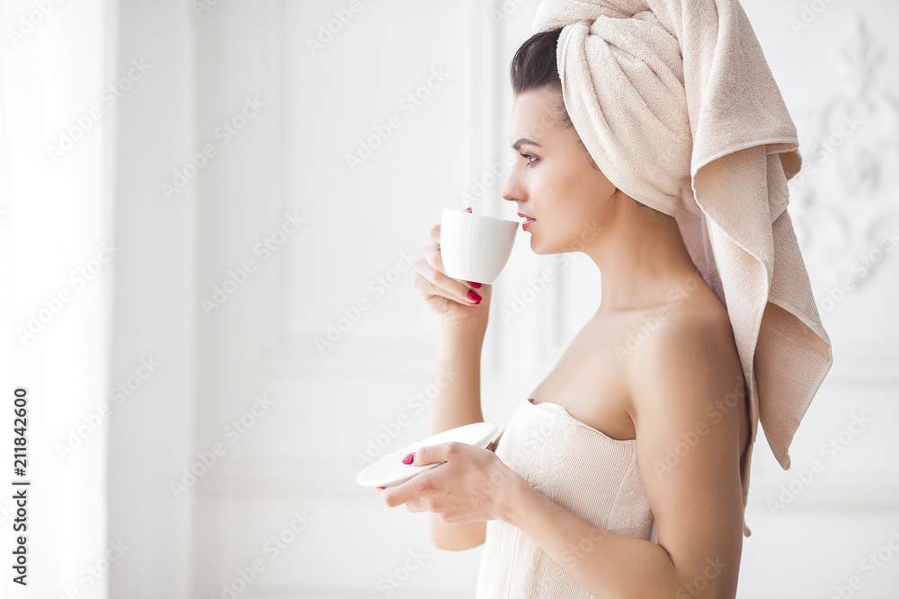 Beautiful woman in the towel after bathing drinking morning coffee Beautiful woman in the towel after bathing drinking morning coffee