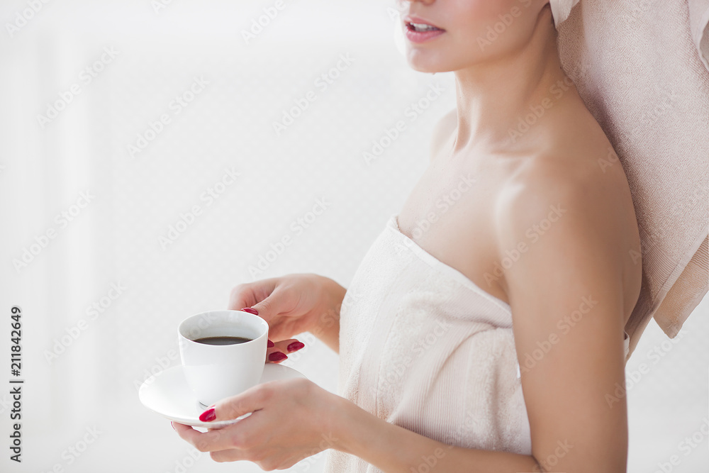 Beautiful woman in the towel after bathing drinking morning coffee Beautiful woman in the towel after bathing drinking morning coffee