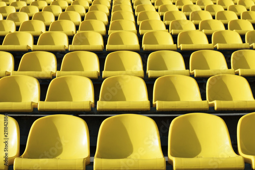 Empty plastic yellow seats at stadium  open door sports arena.