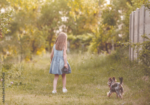 Little girl running with the dog in the countryside photo