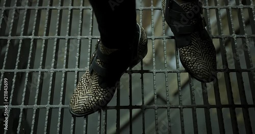 Handheld floaty footage of some fashionable shoes on a grated platform