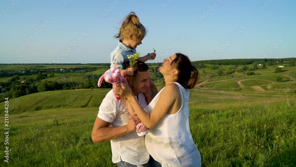 Caucasian pregnant couple with toddler daughter have leisure time outdoors. Happy young parents expecting baby with child at summer sunset. Parenthood, pregnancy, childhood, healthy, activity concept Caucasian pregnant couple with toddler daughter have leisure time outdoors. Happy young parents expecting baby with child at summer sunset. Parenthood, pregnancy, childhood, healthy, activity concept