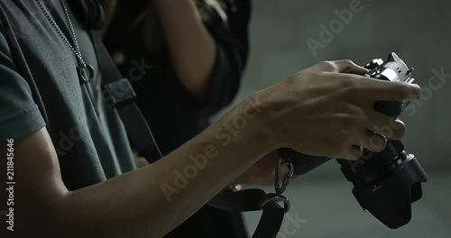 Handheld slow-motion close up footage of photographer holding camera while model looks and points