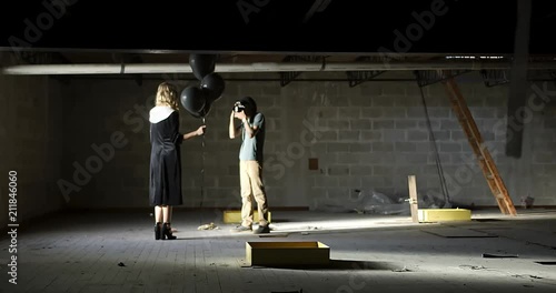 Floaty sliding dolly wide shot of photographer looking through camera at model 