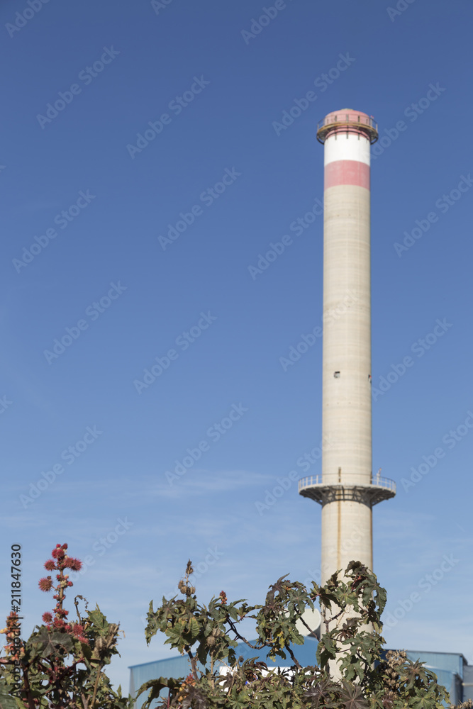 large chimney that rises against the blue sky