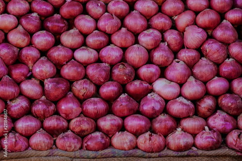 Fresh indian vegetables stored on market stalls: red onions and potatos