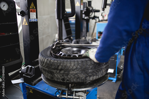 Mechanic repairing tire. Worker vulcanize used tire.
