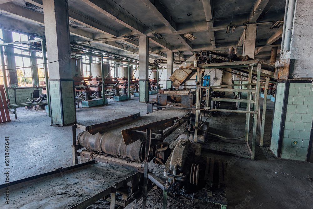 Abandoned tea factory with remnant of rusty equipment. Broken conveyor belt