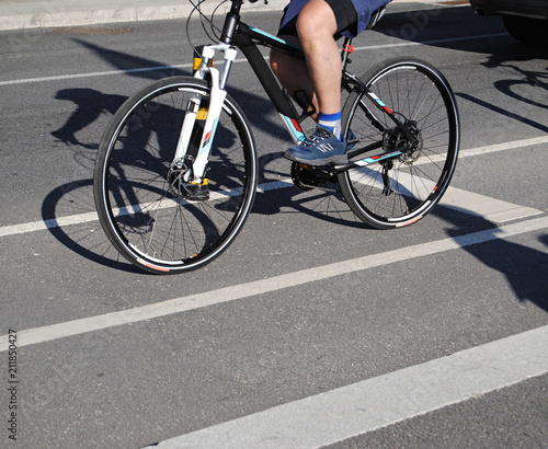 Toca a pedalar homem a pedalar em bicileta hibrida numa estrada de bicicletas