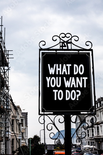 Handwriting text writing What Do You Want To Do Question. Concept meaning Meditate Relax Vacation Travel Desire Vintage black board white letters words cloudy background old city ideas.