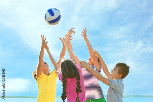Cute children playing with ball outdoors