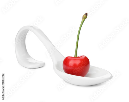 Spoon with sweet red cherry on white background