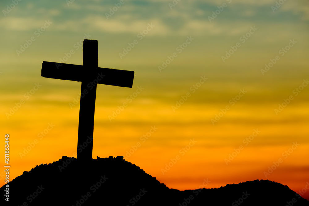 Concept conceptual yellow cross religion symbol silhouette in nature over sunset or sunrise sky