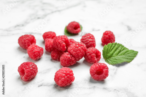 Ripe aromatic raspberries on marble table, closeup