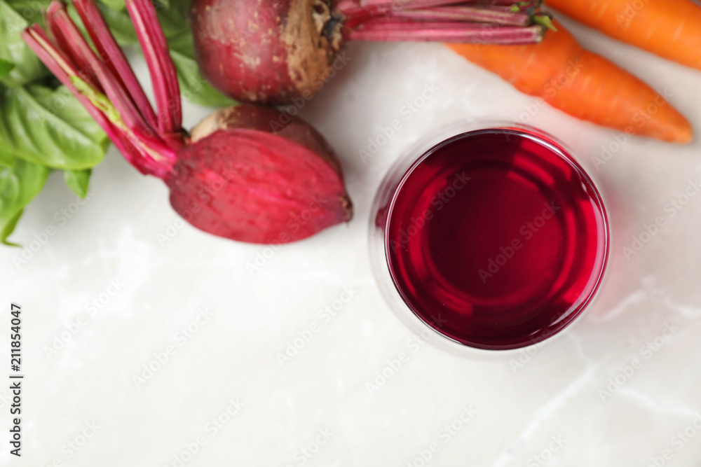 Glass with fresh beet juice and ingredients on table, top view Glass with fresh beet juice and ingredients on table, top view