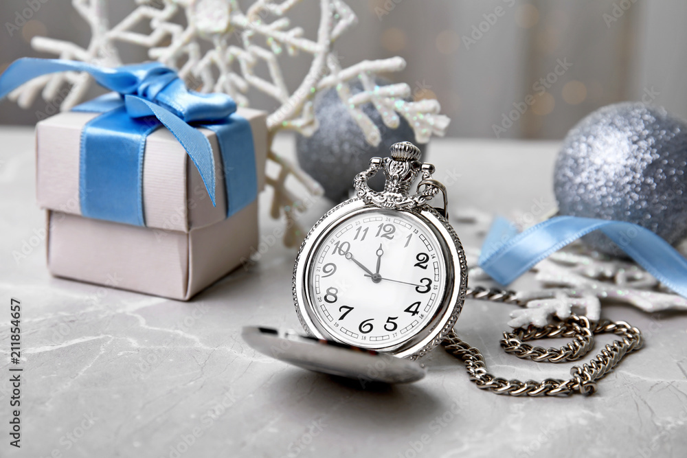 Pocket watch, gift and festive decor on table. Christmas countdown