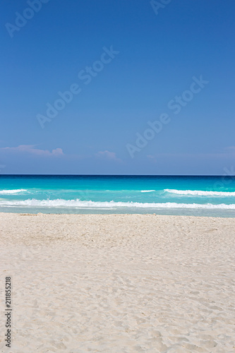 Fototapeta Naklejka Na Ścianę i Meble -  A pristine turquoise sandy beach background with lots of copy space. Useful for design