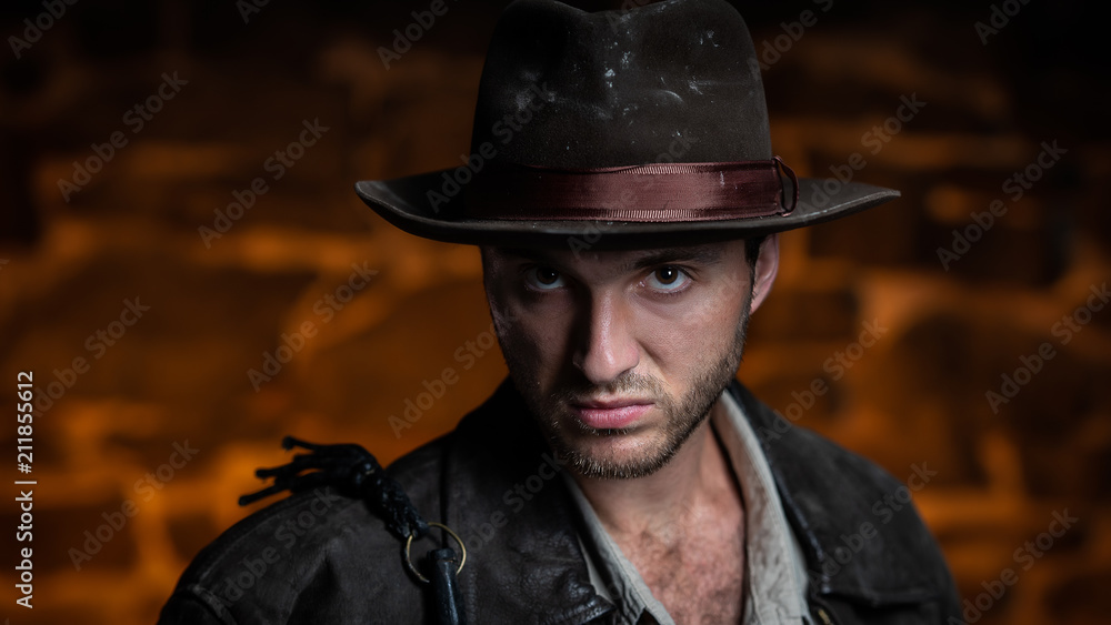 adventurer (Indiana Jones). stone wall background.