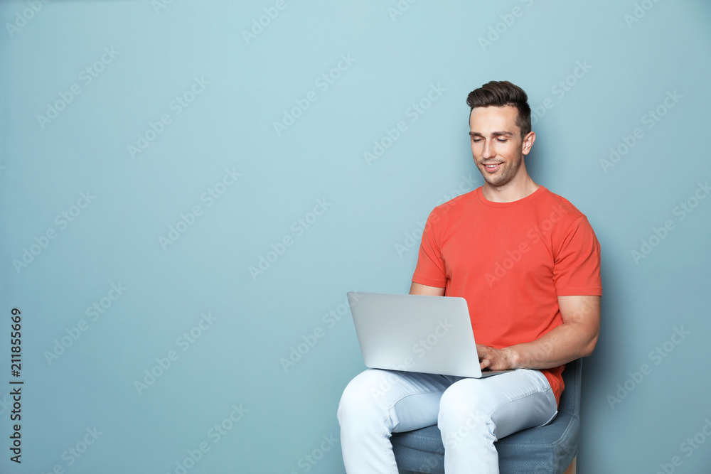 Man in casual clothes with laptop on color background Man in casual clothes with laptop on color background