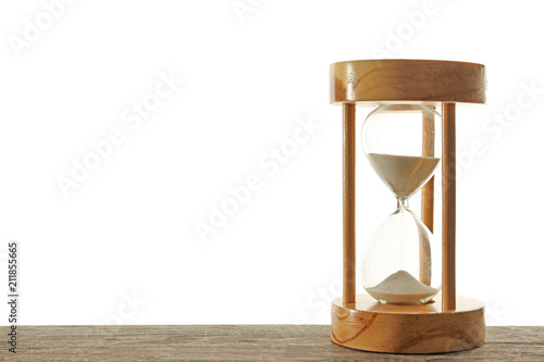 Hourglass with flowing sand on table against light background. Time management © New Africa