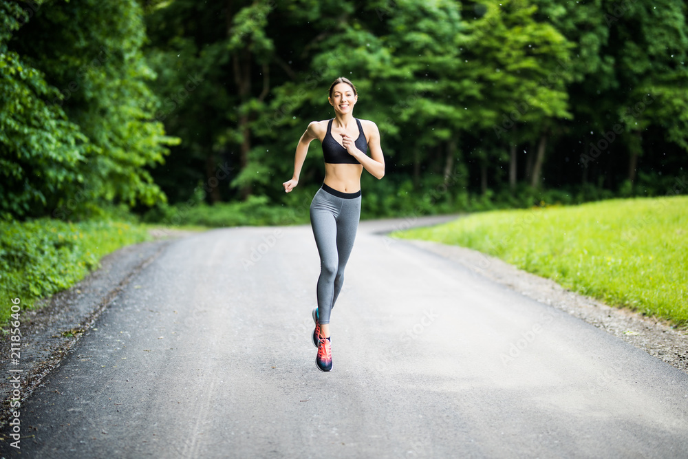 Young lady running. Woman runner running through the spring park road. Workout in a Park. Beautiful fit Girl. Fitness model outdoors. Weight Loss Young lady running. Woman runner running through the spring park road. Workout in a Park. Beautiful fit Girl. Fitness model outdoors. Weight Loss