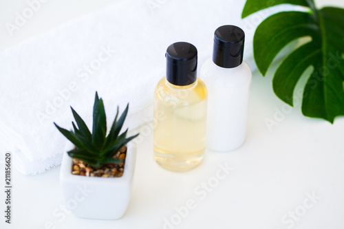 Wellness Products and Cosmetics. Herbal and mineral skincare. Jars of cream, white cosmetic bottles. Without label. Spa Set with soap and white towel.
